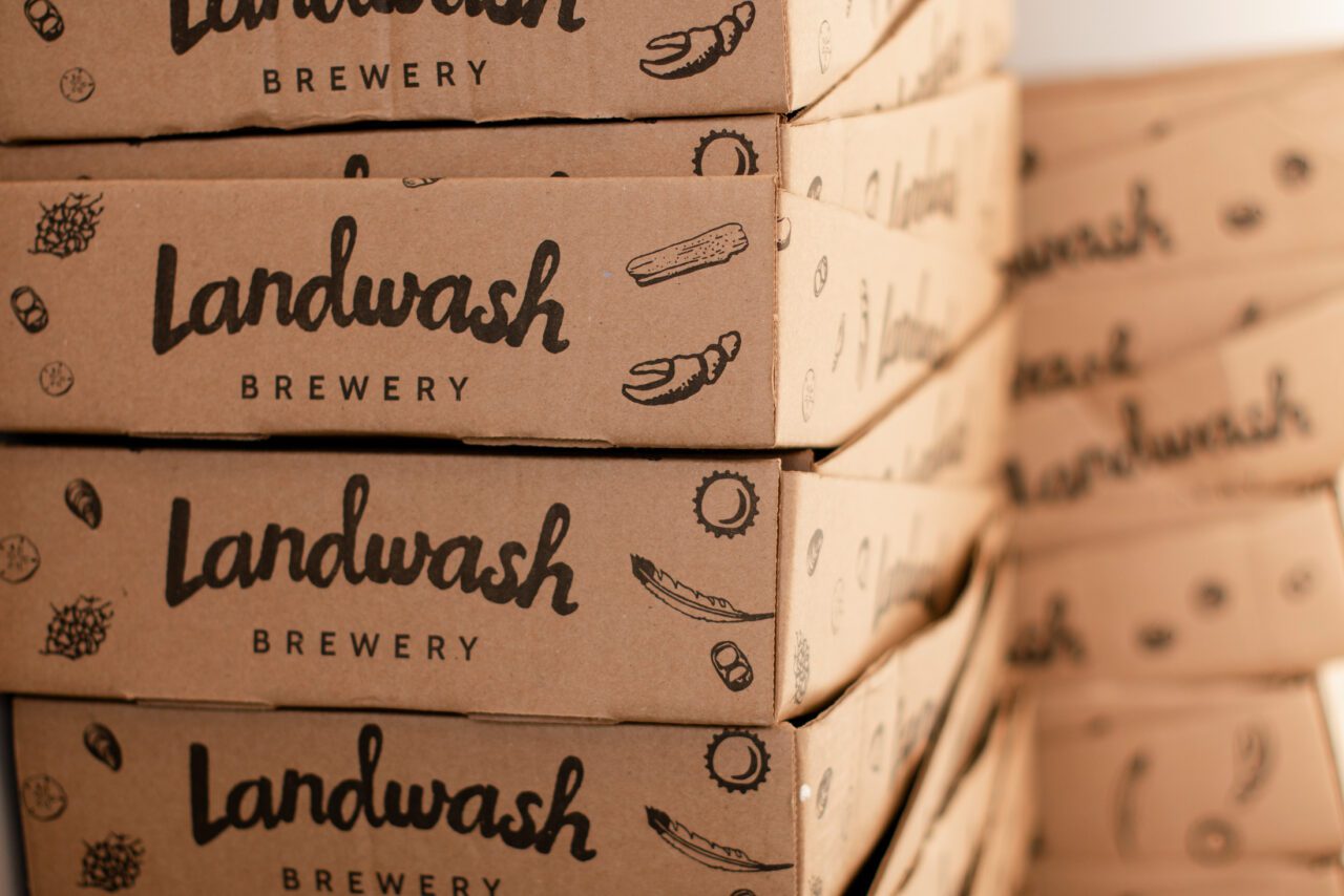 Cardboard beer can trays stacked up and stamped with the Landwash logo
