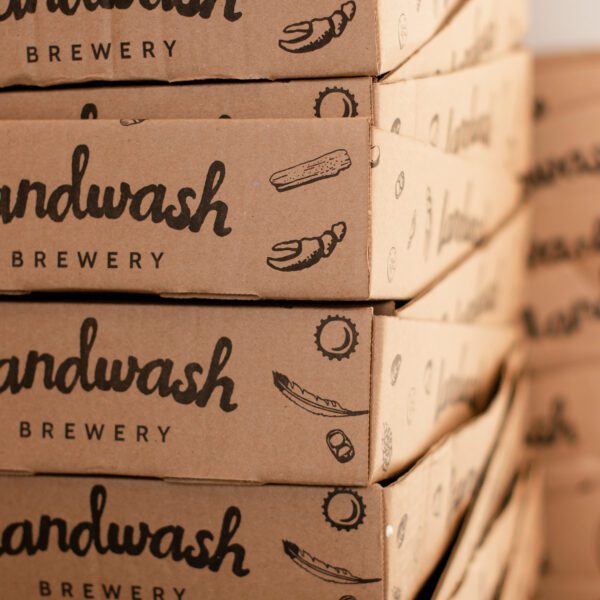 Cardboard beer can trays stacked up and stamped with the Landwash logo